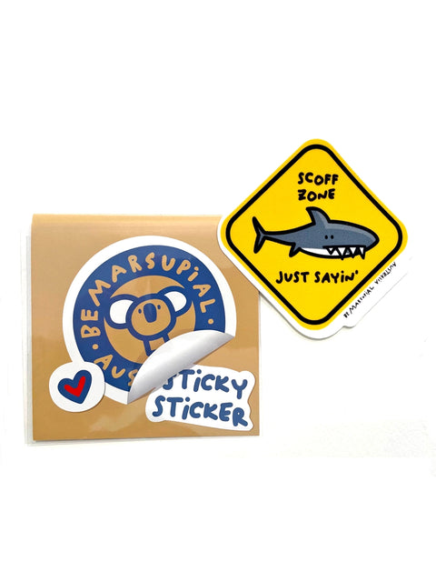 Die-cut vinyl sticker of a shark warning sign that reads: "scoff zone - just saying"