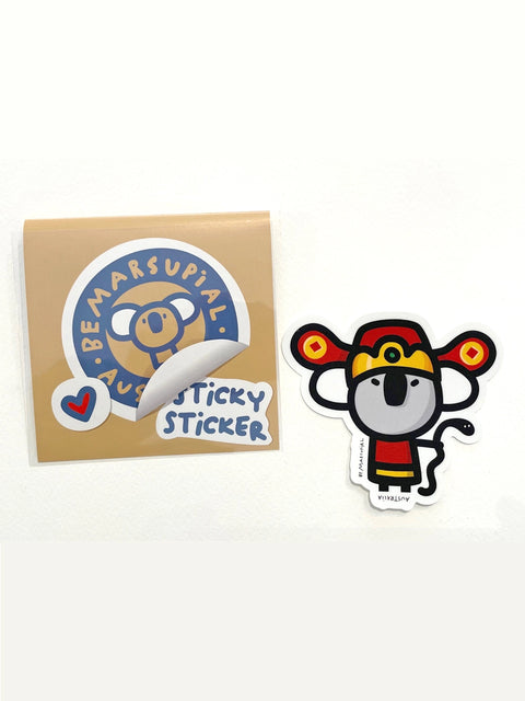 Die-cut vinyl sticker of a koala dressed as the Chinese Fortune deity